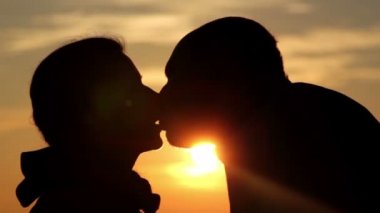 erkek ve kız (yakın çekim güneş doğarken öpüşme)