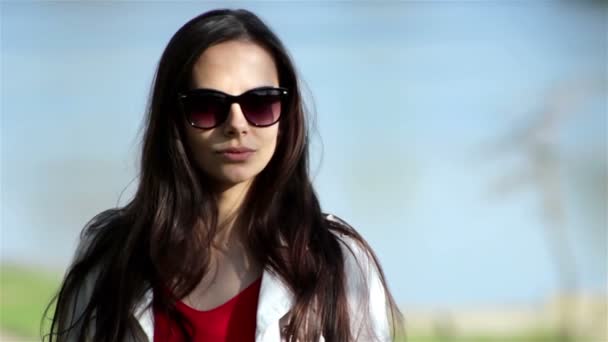 Mujer joven y bonita sonriendo con confianza y mirándote... al aire libre — Vídeos de Stock