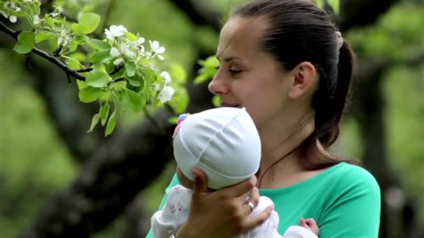 En ung mor med en baby på våren — Stockvideo