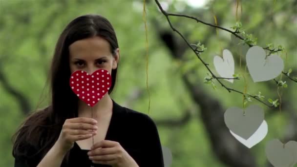 Jeune belle fille avec un cœur en carton dans sa main concept d'amour 