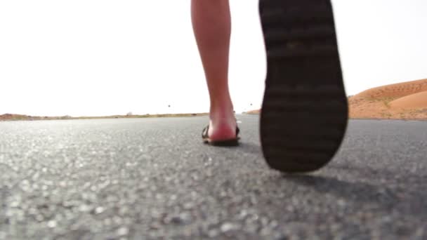 Un joven caminando por el camino en el desierto — Vídeo de stock