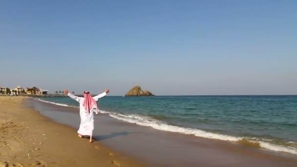 Арабский человек, на пляже. Араб ходит по морю. — стоковое видео