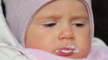 sevimli, küçük bir bebek yeme ile spoon.a şirin bebek isteksizce bebek maması yiyor.
