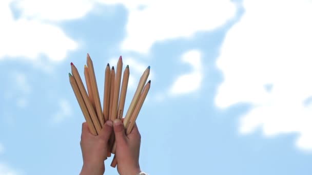 Niño con lápices de colores, Niño con lápices sobre el fondo del cielo, pintura al aire — Vídeo de stock