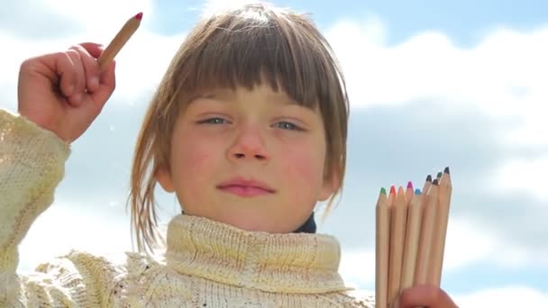 着色された鉛筆、空の背景上に鉛筆を持つ子供を持つ少年を空気でペイントします。 — ストック動画