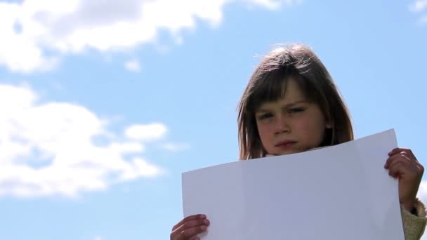 Niño sosteniendo una hoja de papel.Niño sosteniendo una hoja de papel — Vídeo de stock