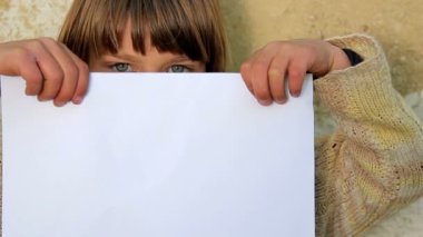 Çocuk bir levha ile paper.child paper.against bir arka plan duvar eski holding holding