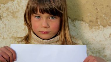 Çocuk bir levha ile paper.child paper.against bir arka plan duvar eski holding holding
