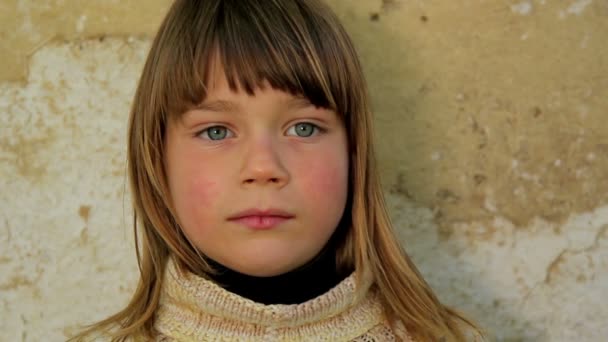 Niño sosteniendo una hoja de papel.Niño sosteniendo una hoja de papel.Sobre el fondo de una vieja pared — Vídeos de Stock