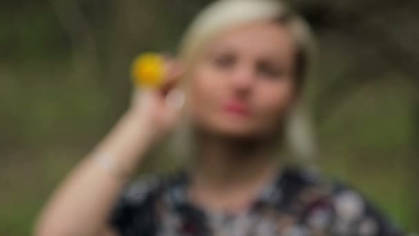 Beautiful young girl with dandelion in the forest — Stock Video