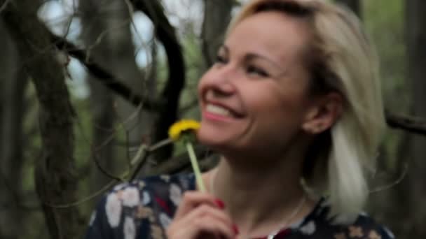 Hermosa chica en el bosque, hermosa joven con diente de león en el bosque — Vídeos de Stock