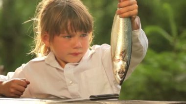 Fish.Little yemek hazırlarken bir deniz fish.child tutan çocuk.