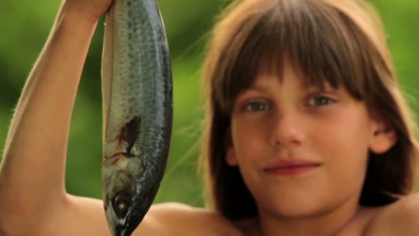 Niño sosteniendo un pez marino.Niño preparando pescado.Pequeño cocinero . — Vídeos de Stock