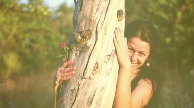 Kız güzel bir park doğa oynak kız ağaç trunk.beautiful saklanıyor.