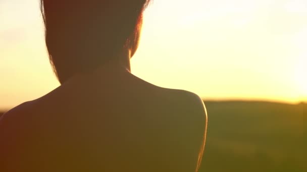 Portret van een meisje bij zonsondergang. silhouet van een meisje uit de achterkant. — Stockvideo