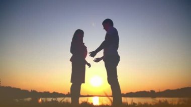 Gün batımında gölde, göl günbatımı, romantik tarihte öpüşme aşık genç çift dans aşık genç çift yavaşça birbirine bakarak birbirlerine, öpücük