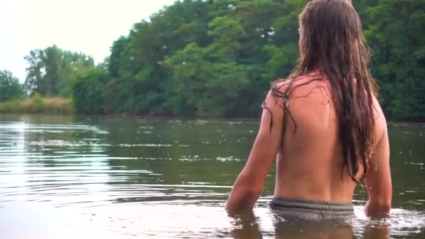 10代の少年が川で入浴している 川の上に眠る長髪の男の肖像画 — ストック動画