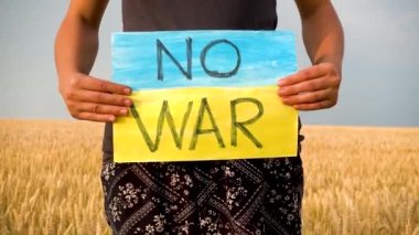 Ukrayna 'daki savaşa karşı yazılmış bir afiş kadınların elinde. Ukrayna 'da savaş. Savaş yok. Savaşı Durdur. 