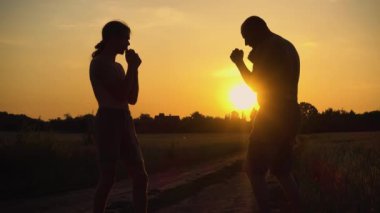 Spor ve eğlence sektörü. Baba oğul gün batımında antrenman yapıyor. Doğada koşan ve boks yapan iki baba ve oğul. Spor, sağlık, eğlence kavramı. 