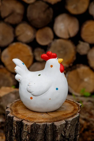 Clay figurine of a chicken on different backgrounds. Handmade clay white chicken. The concept of art, decorative toys, sculpture. 