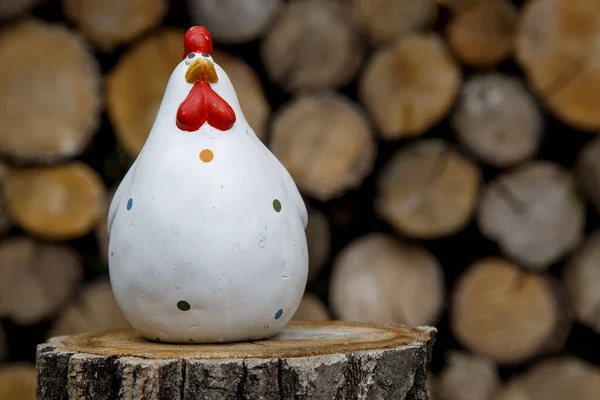 Clay figurine of a chicken on different backgrounds. Handmade clay white chicken. The concept of art, decorative toys, sculpture.