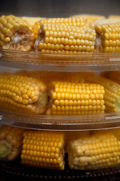 Heads of corn laid out for cooking in a double boiler. Corn broken into pieces in a steamer. The concept of food, vegetarianism, healthy food. 