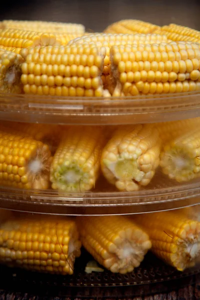 Heads of corn laid out for cooking in a double boiler. Corn broken into pieces in a steamer. The concept of food, vegetarianism, healthy food. 