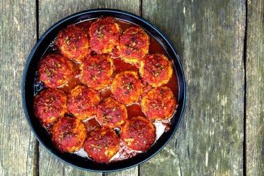 Appetizing fresh meatballs in tomato sauce. Meat dish meatballs in traditional sauce. Meatballs in tomato sauce on the table in a pan. The concept of food, home cooking, haute cuisine. 