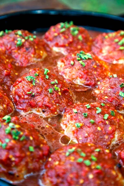 Appetizing fresh meatballs in tomato sauce. Meat dish meatballs in traditional sauce. Meatballs in tomato sauce on the table in a pan. The concept of food, home cooking, haute cuisine. 