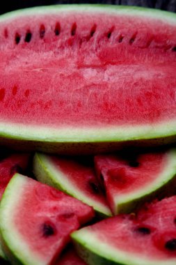 Juicy fresh red watermelon on the table. Watermelon sliced into pieces on a wooden texture background. The concept of food, happiness, sweets and desserts. 