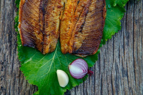 Sea fish cooked on the barbecue. Sea fish fillet baked on the grill. The concept of folk cuisine, restaurant, cooking. 