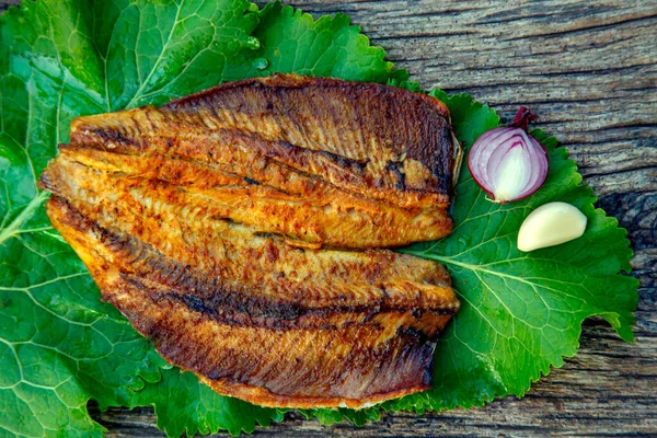 Sea fish cooked on the barbecue. Sea fish fillet baked on the grill. The concept of folk cuisine, restaurant, cooking. 