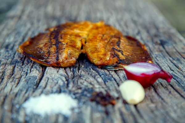 Sea fish cooked on the barbecue. Sea fish fillet baked on the grill. The concept of folk cuisine, restaurant, cooking. 
