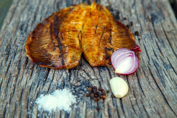 Sea fish cooked on the barbecue. Sea fish fillet baked on the grill. The concept of folk cuisine, restaurant, cooking. 