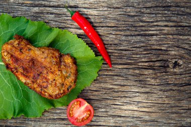 Meat steak cooked on the barbecue. Grilled fresh meat steak with spices and red pepper. Ready steak on the table with tomatoes and peppers. The concept of food, restaurants, traditional cuisine. 