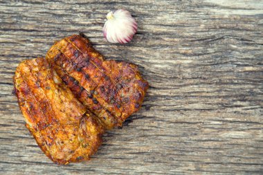 Meat steak cooked on the barbecue. Grilled fresh meat steak with spices and red pepper. Ready steak on the table with tomatoes and peppers. The concept of food, restaurants, traditional cuisine. 