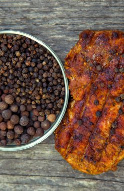Meat steak cooked on the barbecue. Grilled fresh meat steak with spices and red pepper. Ready steak on the table with tomatoes and peppers. The concept of food, restaurants, traditional cuisine. 