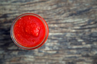 Masadaki kavanozda domates ezmesi hazır. Cam kasede domates ketçap sosu. Sos, baharat ve koruma kavramı.. 