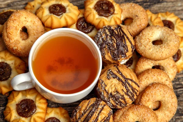 Homemade sweet cookies with tea. Delicious sweet cookies with tea on the table. Dessert cookies with tea in a cafe. The concept of desserts, sweets, coffee shop.