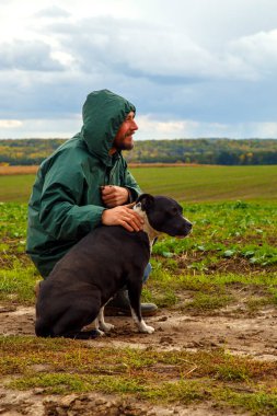 Bir adam fırtınadan sonra köpeğini bir tarlada gezdirir. Bulutlu bir günde doğada çalışan bir teriyeri olan bir adam. Özgürlük, mutluluk, arkadaşlık, doğa kavramı.. 