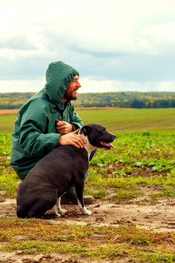 Bir adam fırtınadan sonra köpeğini bir tarlada gezdirir. Bulutlu bir günde doğada çalışan bir teriyeri olan bir adam. Özgürlük, mutluluk, arkadaşlık, doğa kavramı.. 