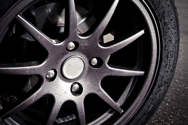 Колесо спортивного автомобиля на мокрой трассе
