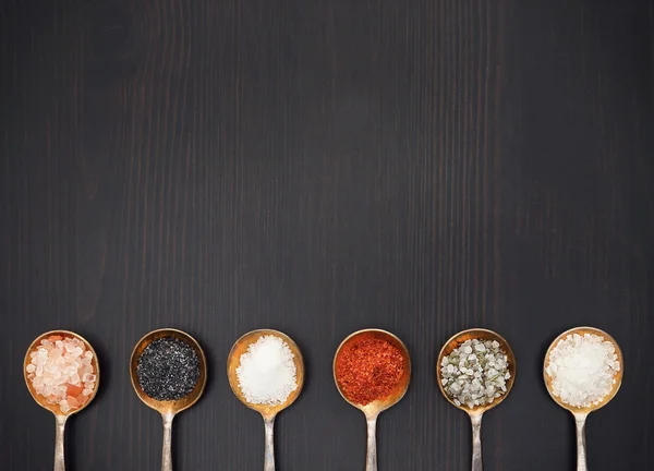 Assortment of salt on a wooden background — Stock Photo, Image