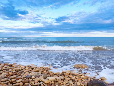 Sea shore beach. Blue waves and clouds on landscape. Beautiful coastline on summer vacation.