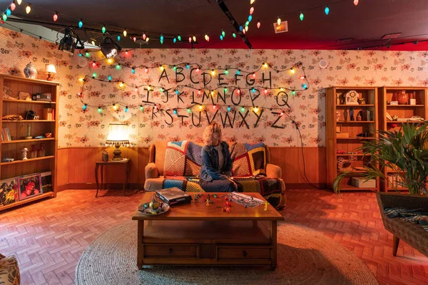 Paris, Fransa - 27 Haziran 2022: Turist kız, Joyce 'un oturma odasında Champs Elysees Bulvarı' ndaki Yabancı Şeyler mağazasında duvarında ışıklar ve alfabelerle fotoğraf çekiyor.