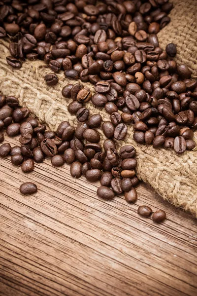 Granos de café frescos sobre fondo de madera — Foto de Stock