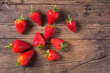 Eski ahşap arka planda taze çilekler.