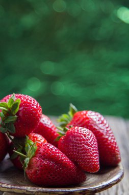 çilek eski ahşap-yeşil bokeh arka ışık ile geri