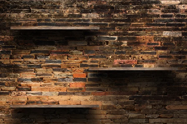 Lege houten planken op oude bakstenen muur achtergrond, grunge industriële interieur ongelijke diffuse verlichting versie. — Stockfoto