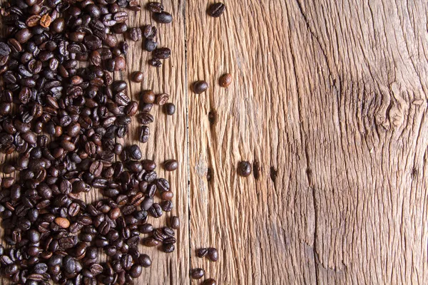 Grãos de café em fundo de madeira — Fotografia de Stock